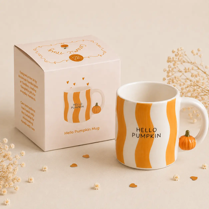 Hello Pumpkin ceramic mug shown with its gift box in an autumn-inspired setting